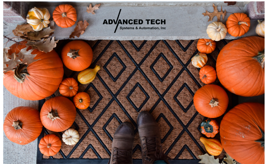 Photo of a doormat surrounded by pumpkins with someone standing on the front and the Advanced Tech Systems & Automation logo on the top center of the image.