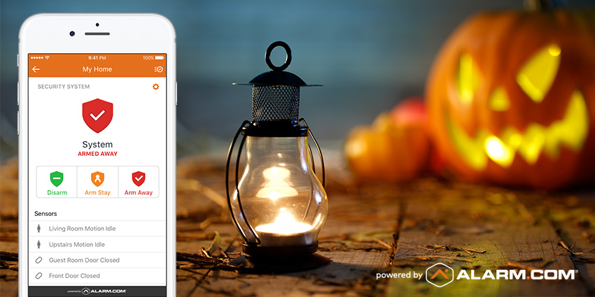 smartphone displaying alarm.com security options with jack o lantern in the background